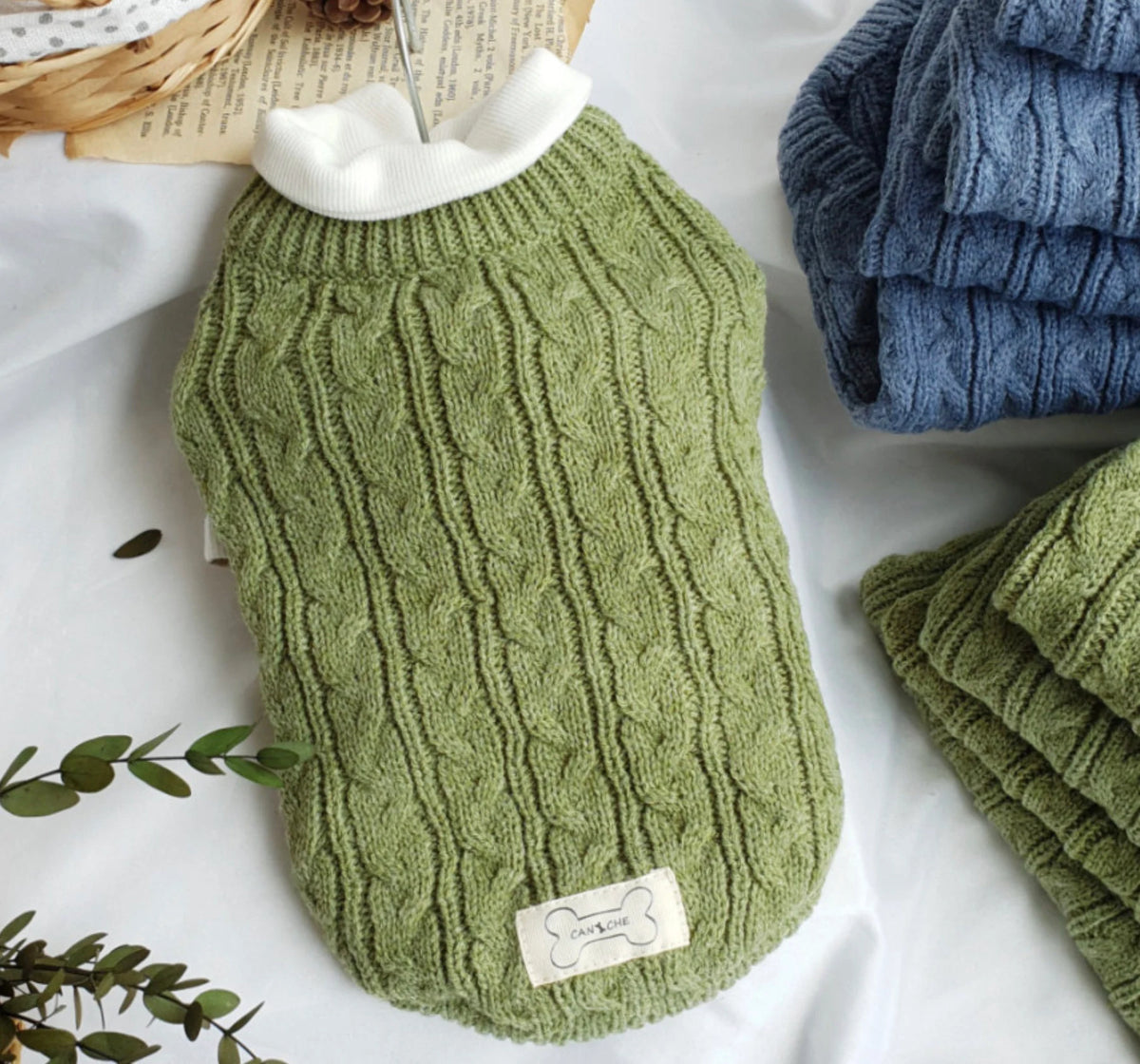 Olive cable-knit sweater layered over a separate white shirt