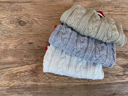 Stack of cable-knit dog vests