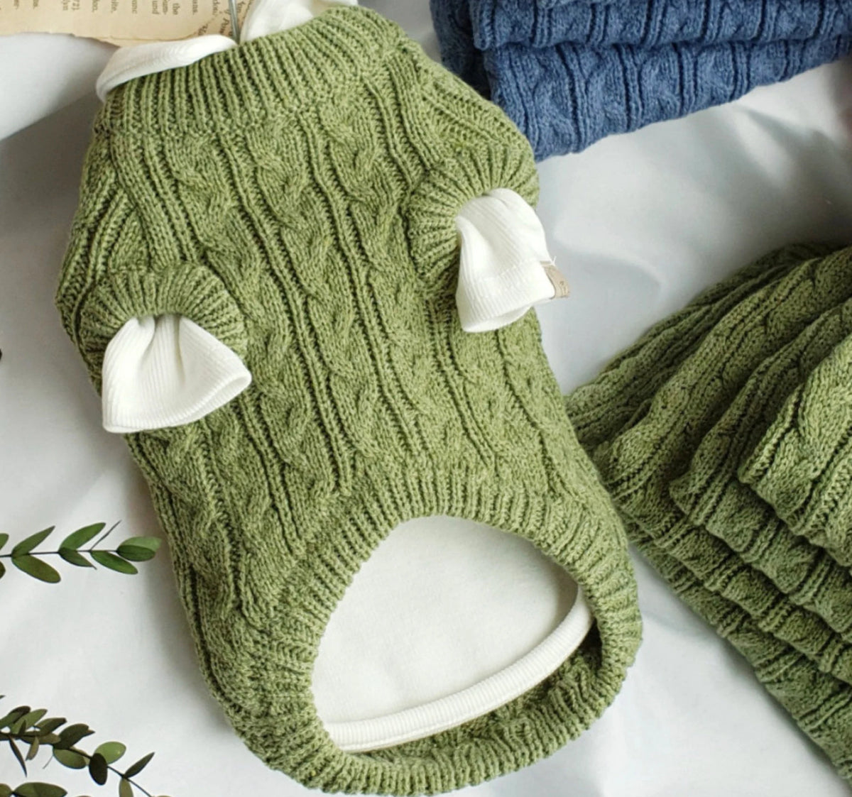 Underside of an olive sweater styled with a separate white shirt